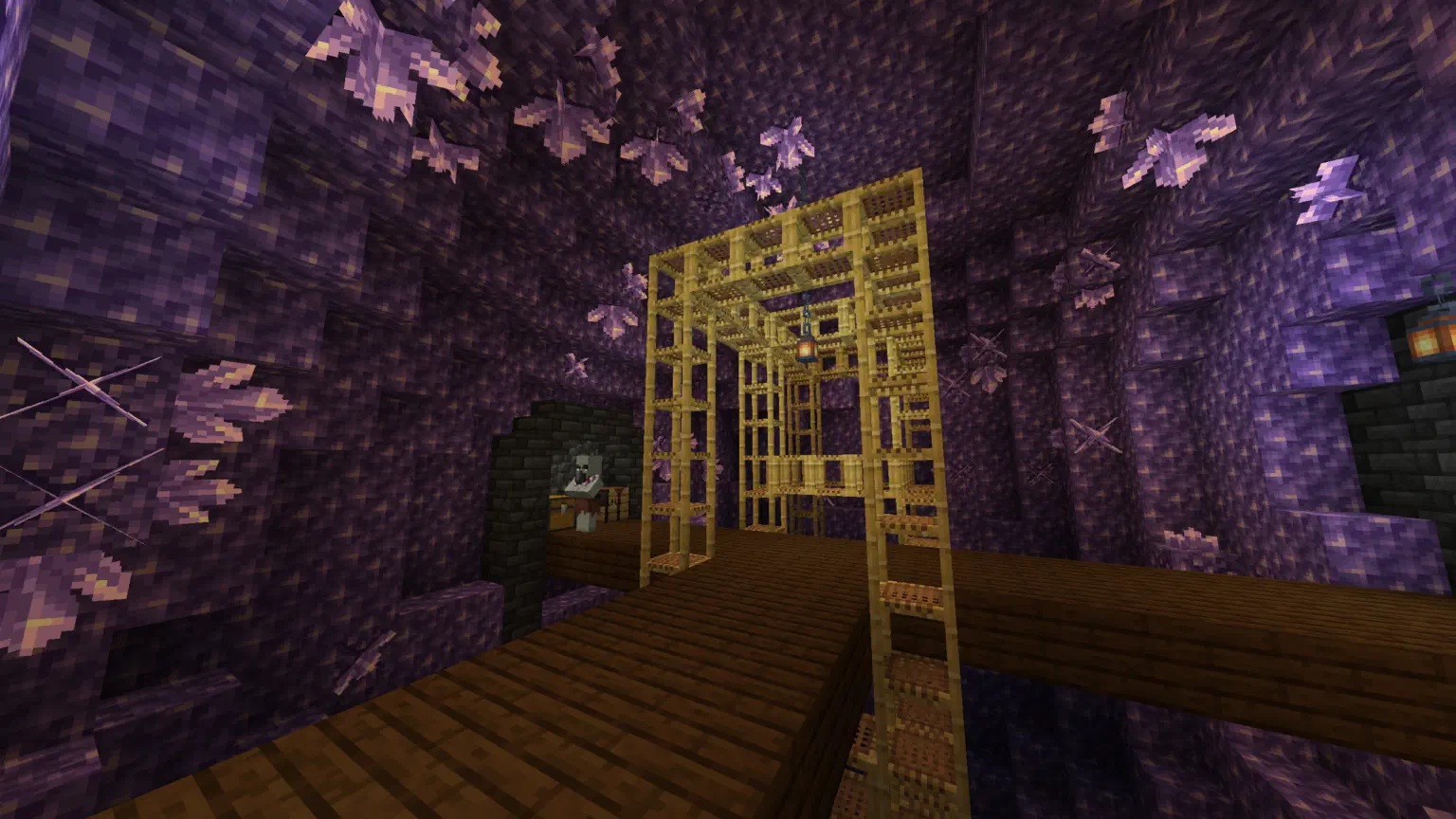 A geode outpost center room, showing a large geode filled with scaffolding and dark oak flooring, as well as a geomancer and chest